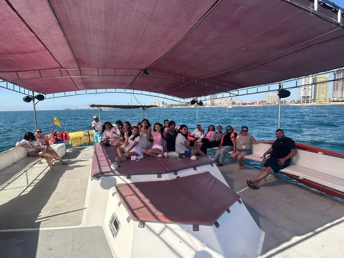 Grupo grande de invitados sentados en la cubierta del catamarán
