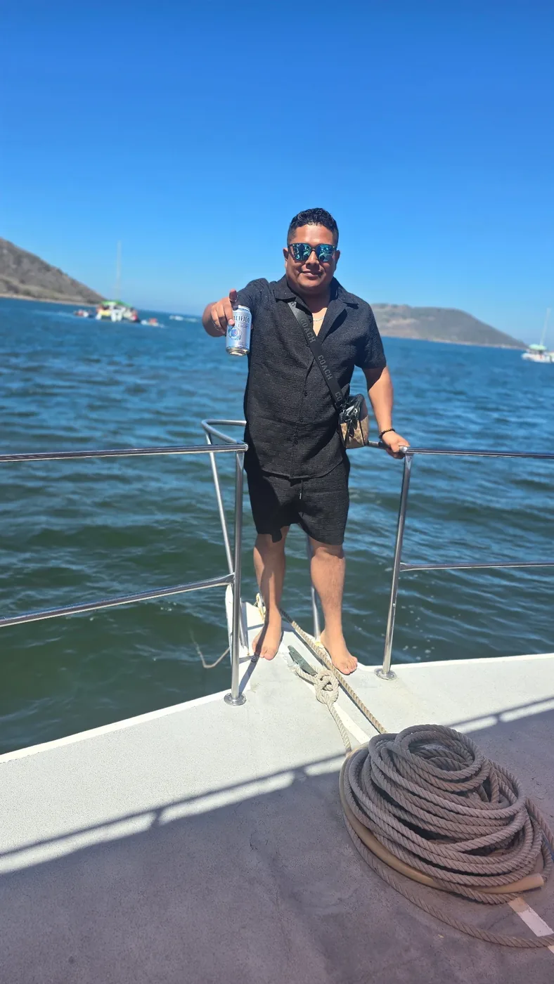 Invitado con una bebida en la popa del yate