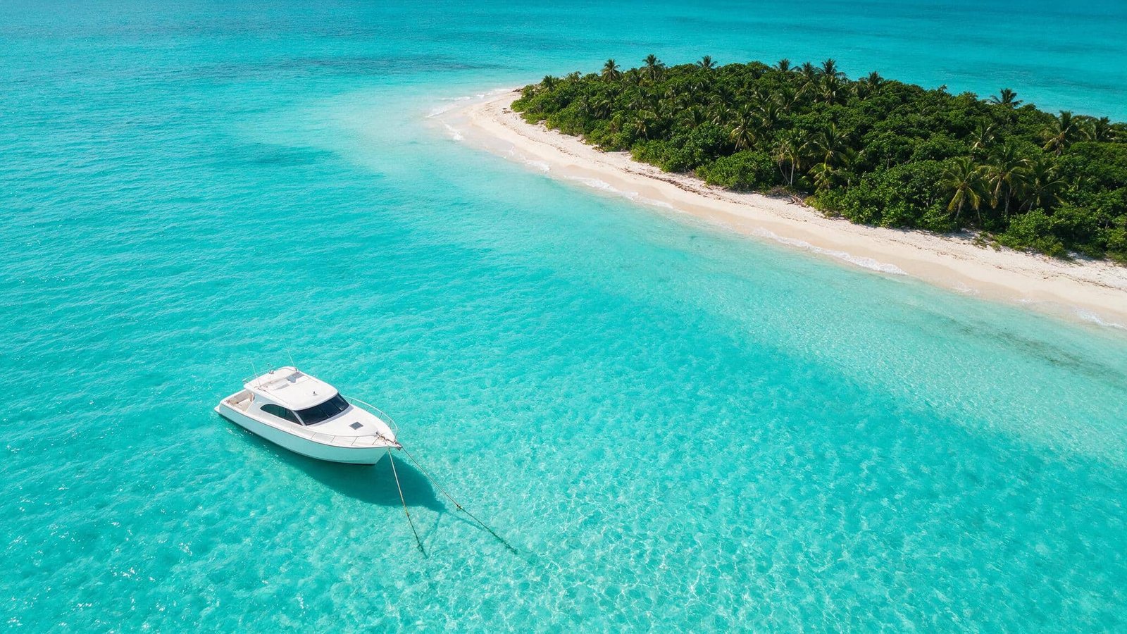 Vista aérea del barco sobre agua turquesa para una boda en la playa Cancún
